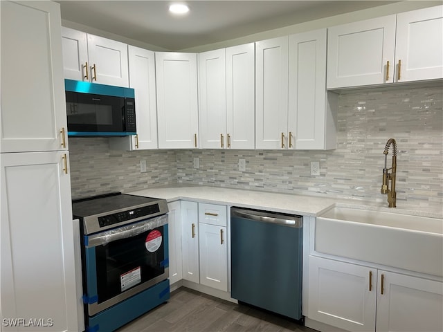 kitchen with sink, appliances with stainless steel finishes, dark hardwood / wood-style floors, tasteful backsplash, and white cabinetry