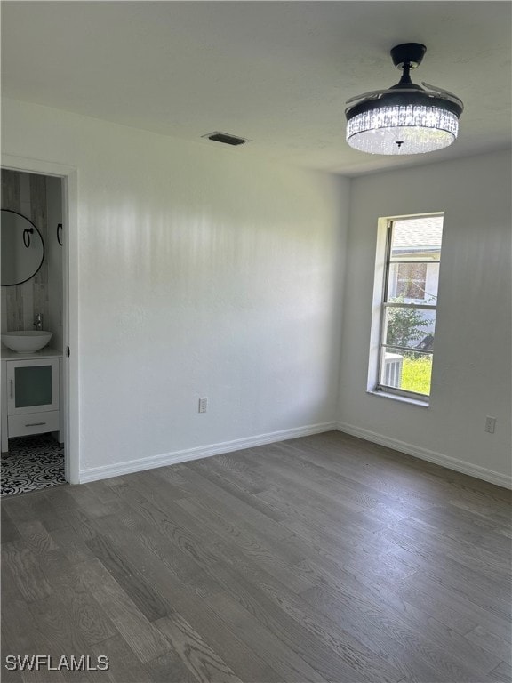 unfurnished room featuring sink and hardwood / wood-style flooring