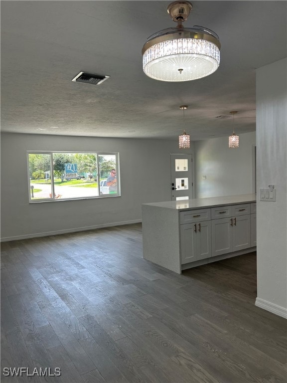 kitchen featuring decorative light fixtures, white cabinetry, and dark hardwood / wood-style floors