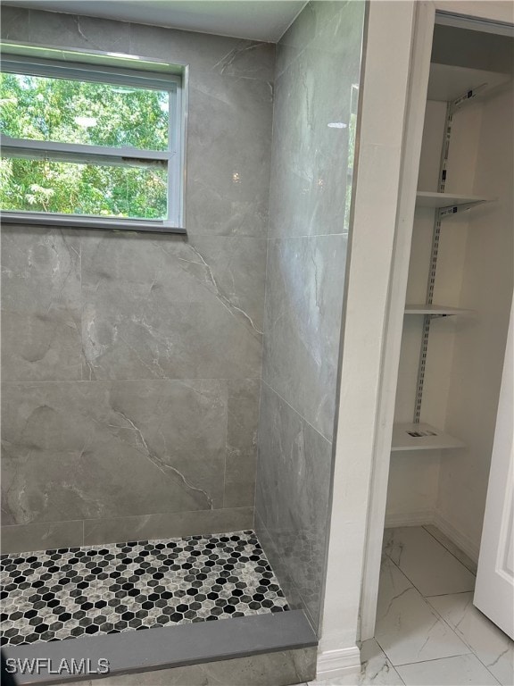 bathroom featuring tiled shower and tile patterned floors