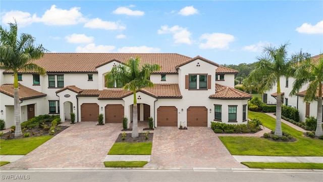 mediterranean / spanish house with a garage and a front lawn