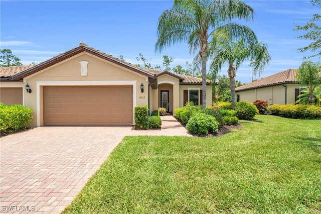 view of front of property with a front yard and a garage