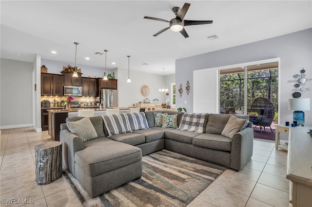 living room featuring ceiling fan with notable chandelier and light tile patterned flooring