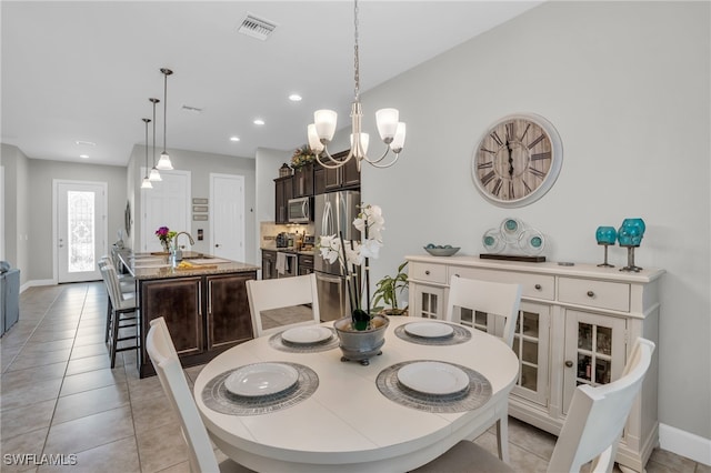 dining room with light tile patterned flooring, sink, and a chandelier