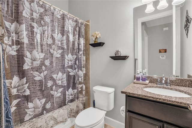 full bathroom featuring toilet, shower / bath combo with shower curtain, and vanity