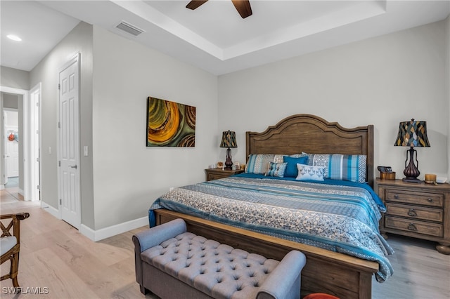 bedroom featuring a closet, ceiling fan, a raised ceiling, and hardwood / wood-style flooring