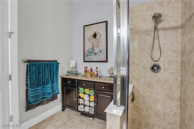 bathroom with tile patterned floors, a tile shower, and vanity