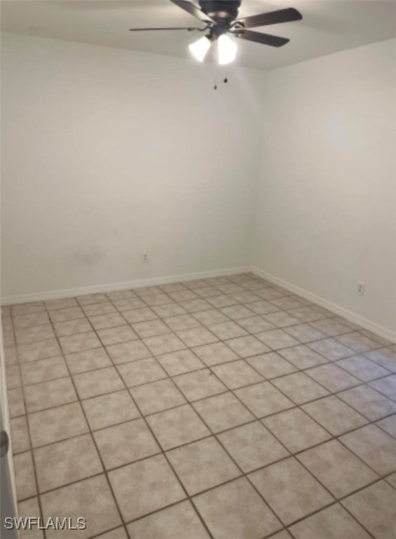 spare room with ceiling fan and light tile patterned floors