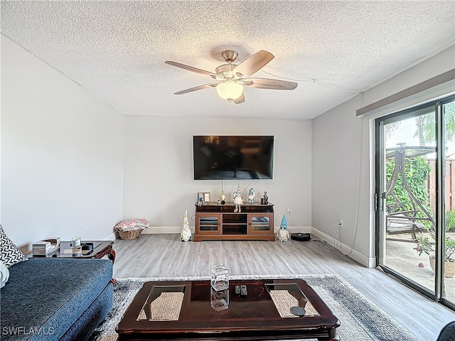 living room with a textured ceiling, ceiling fan, and hardwood / wood-style floors