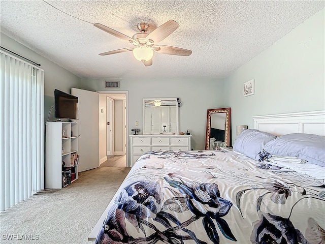 carpeted bedroom featuring a textured ceiling and ceiling fan