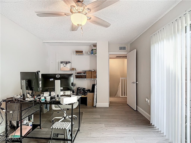 office with light hardwood / wood-style floors, a textured ceiling, and ceiling fan