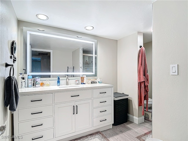 bathroom featuring a shower with door and vanity