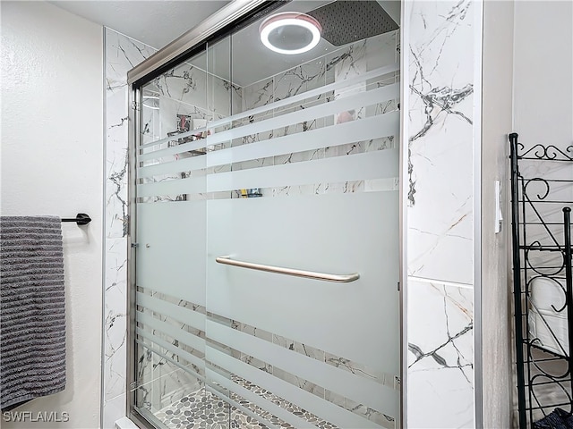 bathroom with a shower with door