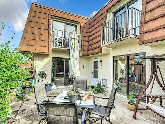 back of house featuring a balcony and a patio area