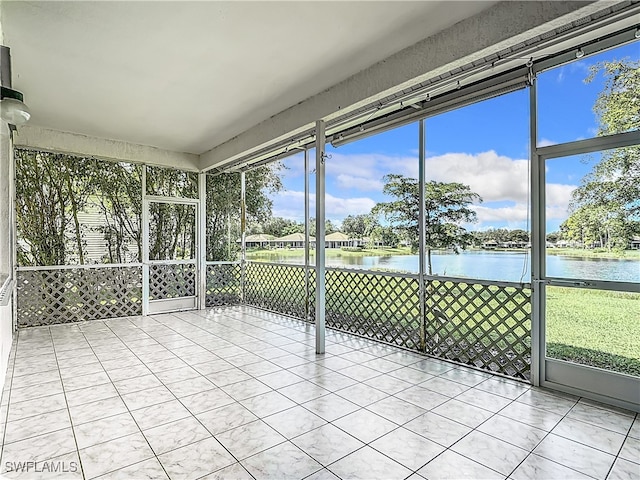 unfurnished sunroom featuring a water view