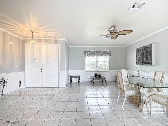 unfurnished dining area featuring ceiling fan, a textured ceiling, and ornamental molding