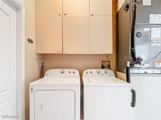 washroom with cabinets and washing machine and dryer