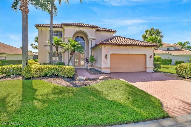 mediterranean / spanish house with a garage and a front yard