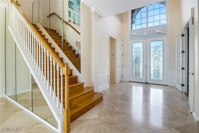 foyer entrance with a high ceiling and french doors