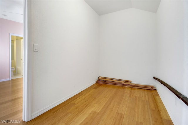 spare room with vaulted ceiling and light wood-type flooring