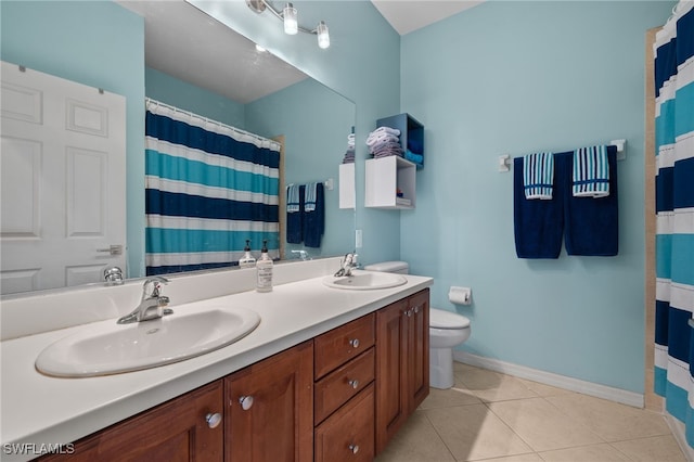 bathroom with toilet, vanity, and tile patterned flooring