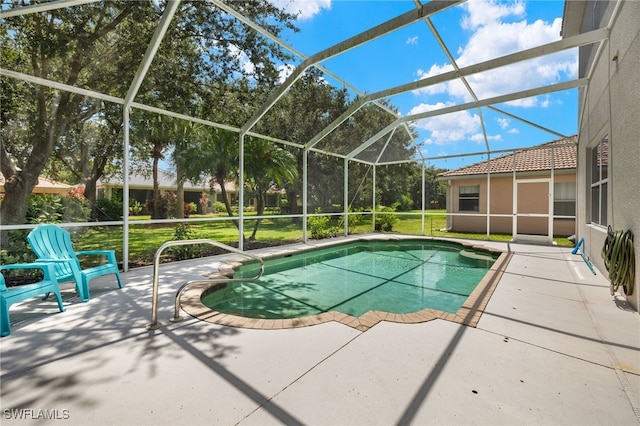 view of swimming pool featuring glass enclosure, a patio, and a yard