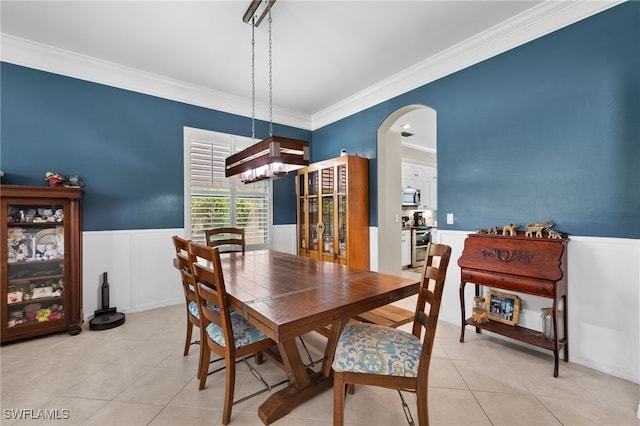 tiled dining space featuring crown molding