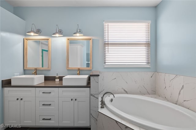 bathroom with double sink vanity and tiled bath