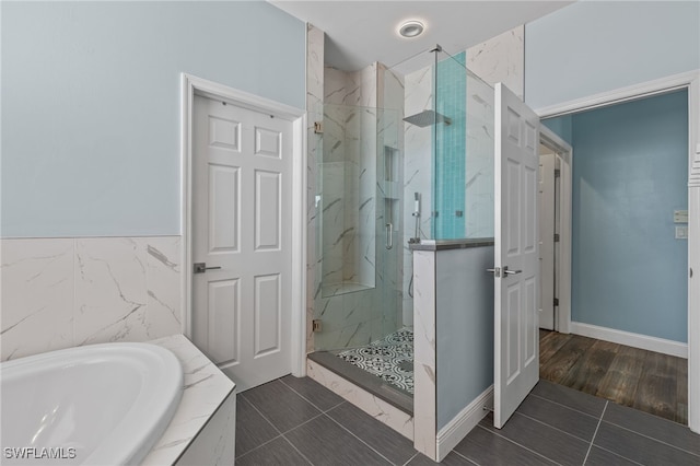 bathroom featuring hardwood / wood-style flooring, plus walk in shower, and sink