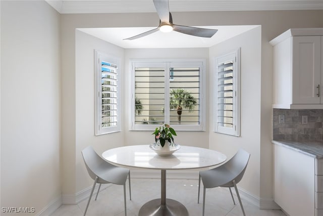 dining room featuring baseboards, a ceiling fan, a wealth of natural light, and crown molding