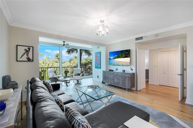 living area with light wood-style floors, visible vents, crown molding, and baseboards