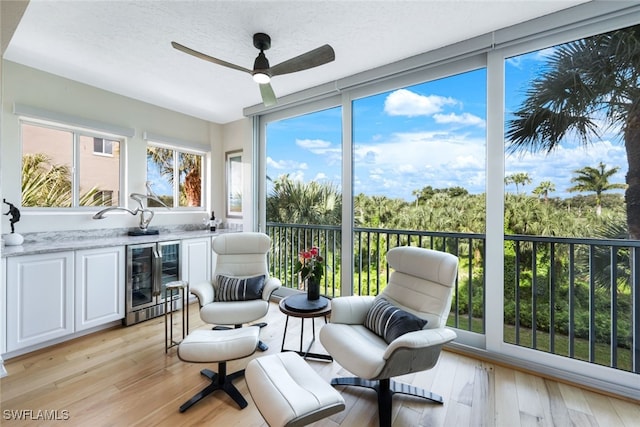 sunroom / solarium with beverage cooler and a ceiling fan