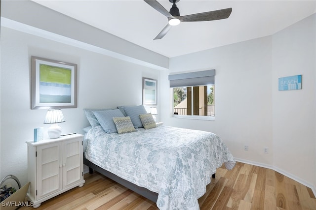 bedroom with light wood-type flooring, ceiling fan, and baseboards