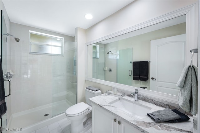 bathroom with toilet, a shower stall, and vanity