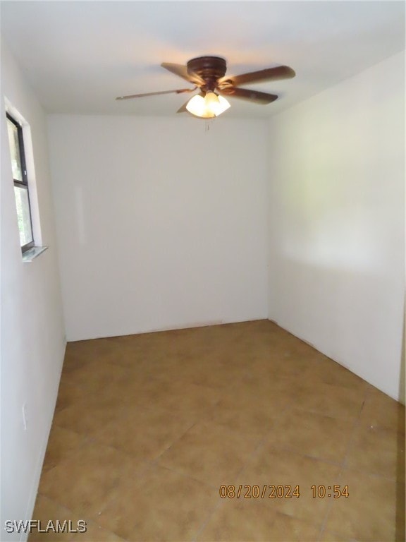 spare room with ceiling fan and light tile patterned floors