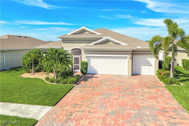 view of front of home featuring a garage, decorative driveway, a front yard, and stucco siding