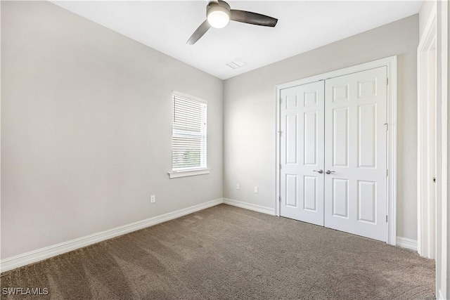 unfurnished bedroom featuring a ceiling fan, a closet, baseboards, and carpet flooring