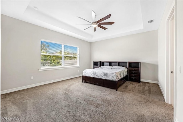 bedroom featuring carpet, baseboards, visible vents, and a raised ceiling