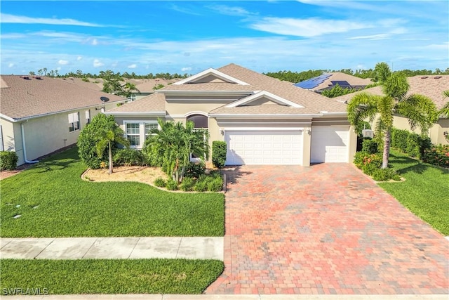 view of front facade with an attached garage, decorative driveway, a residential view, stucco siding, and a front yard