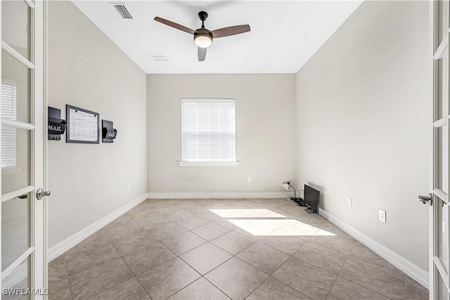 tiled empty room featuring ceiling fan, visible vents, baseboards, and french doors