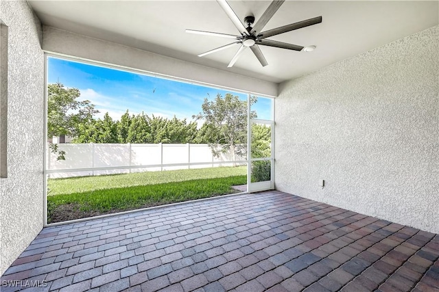 unfurnished sunroom featuring ceiling fan