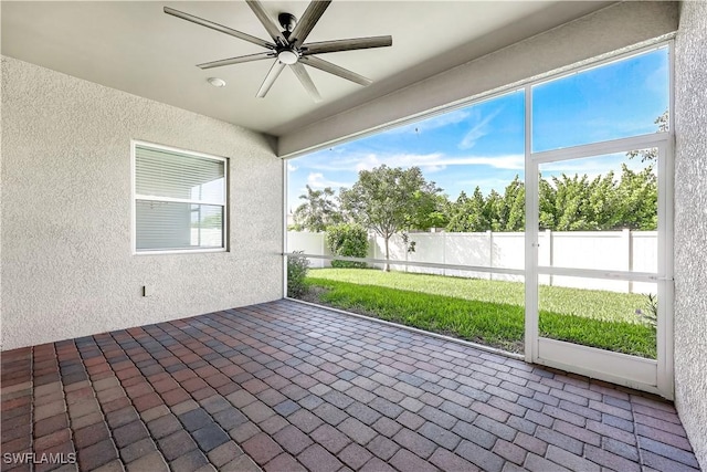 unfurnished sunroom featuring ceiling fan