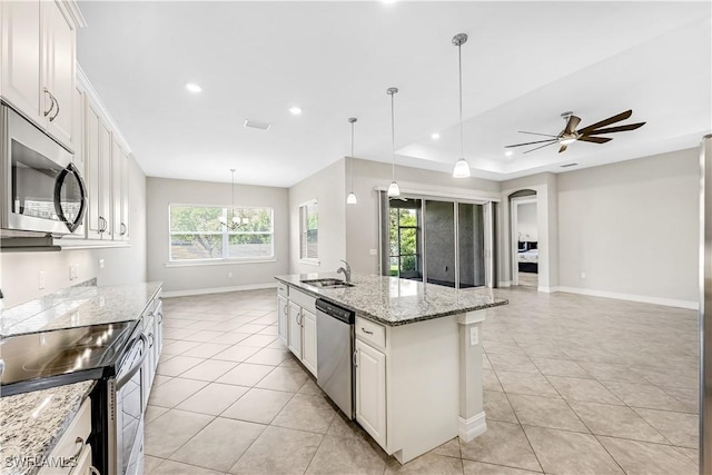 kitchen featuring light tile patterned floors, stainless steel appliances, a sink, and open floor plan