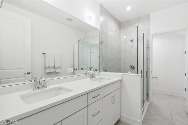 bathroom featuring a shower with shower door, vanity, and tile patterned flooring