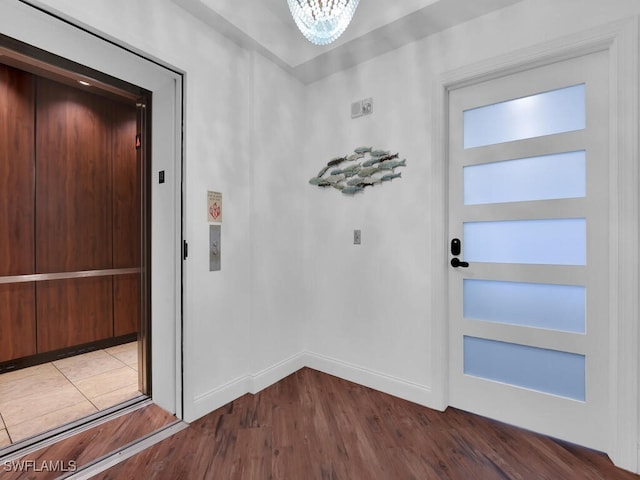 doorway to outside with dark hardwood / wood-style floors and elevator