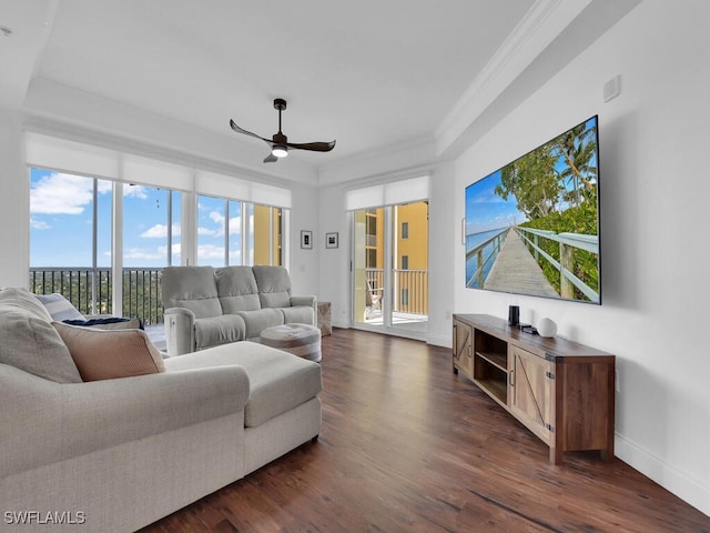 living room featuring ceiling fan, ornamental molding, and dark hardwood / wood-style floors