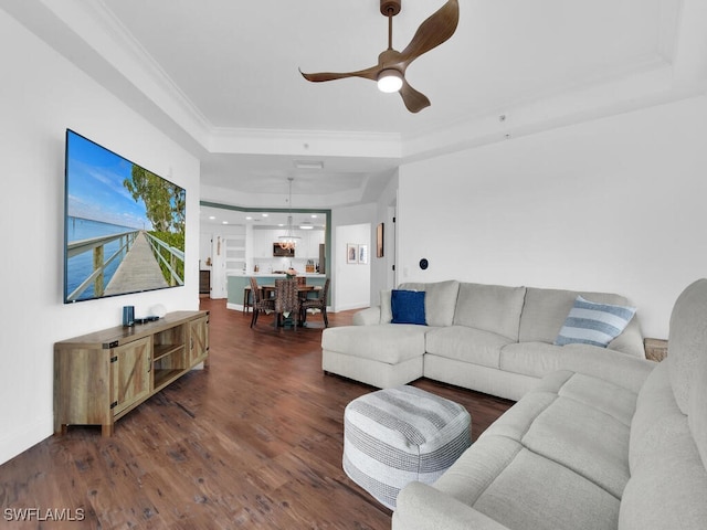 living room featuring ceiling fan, a raised ceiling, and dark hardwood / wood-style flooring