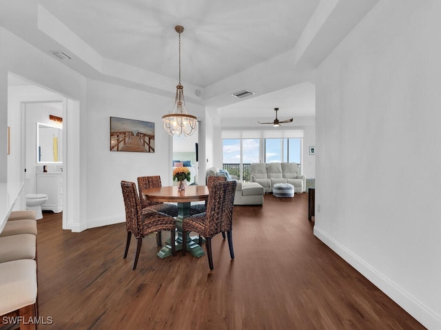 dining space with ceiling fan with notable chandelier and dark wood-type flooring