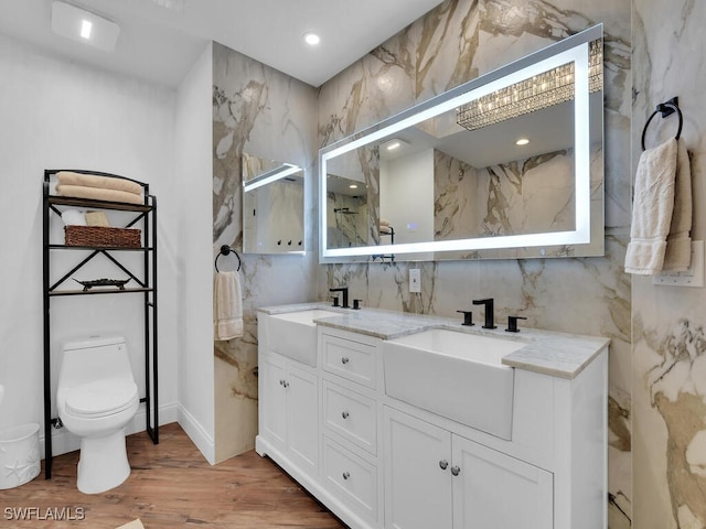 bathroom featuring tile walls, wood-type flooring, vanity, and toilet