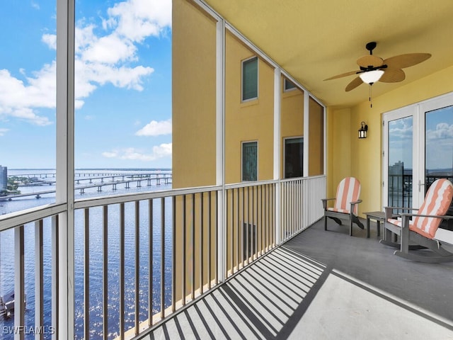 balcony featuring ceiling fan and a water view